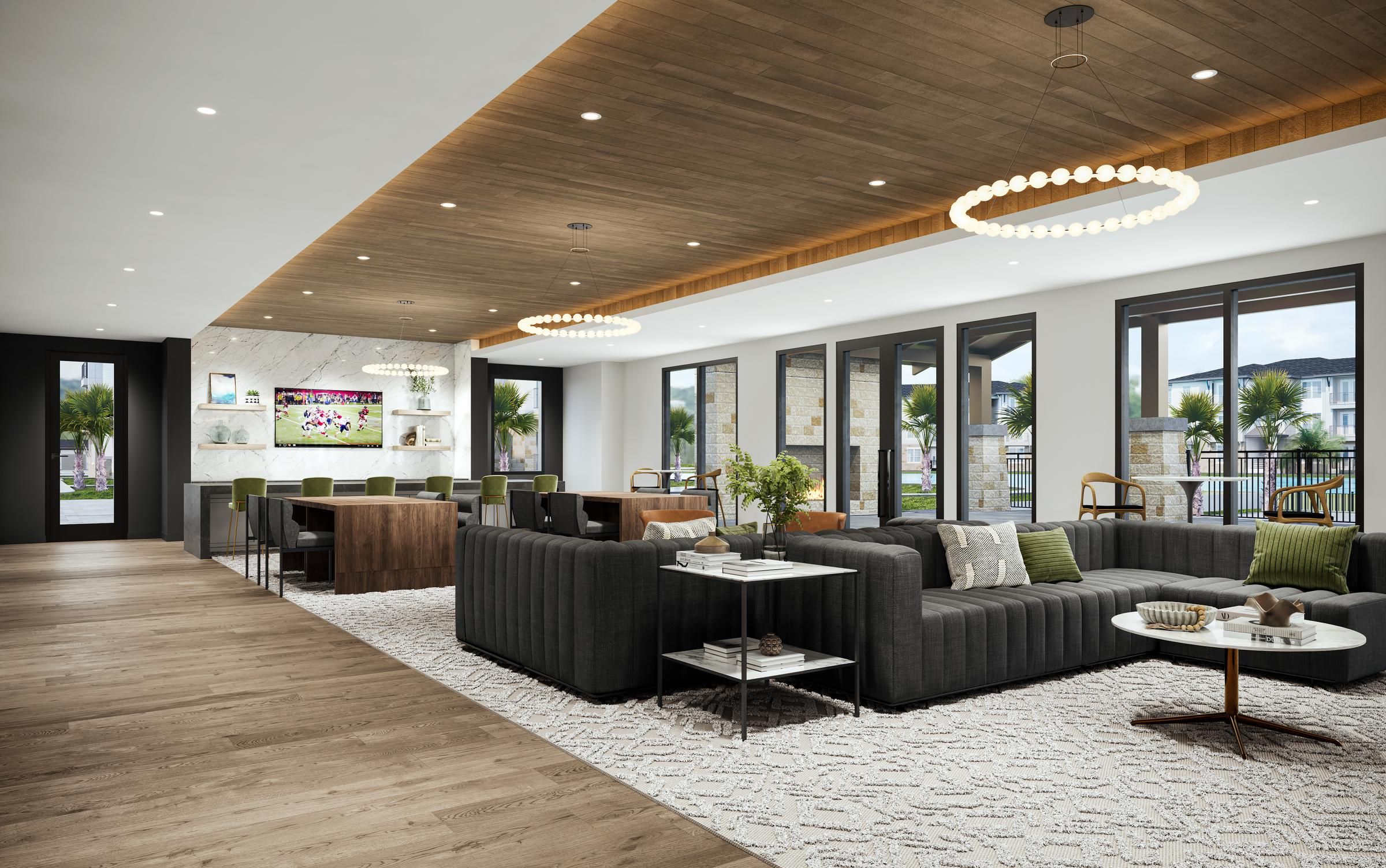 Modern lounge with black sofas, circular light fixtures, large windows, and a view of the open kitchen area.